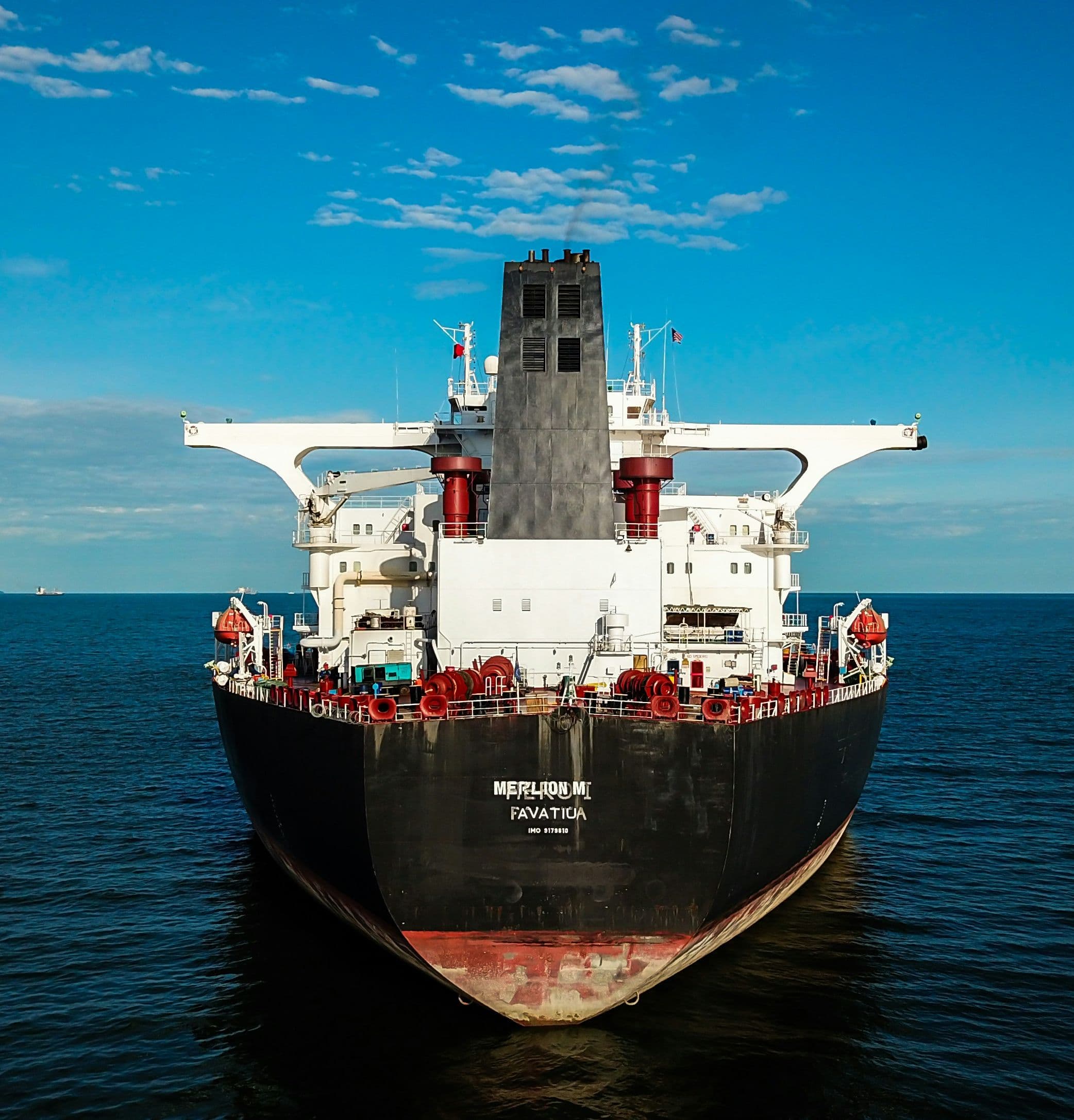 Loaded tanker escorted by tugboats at sea