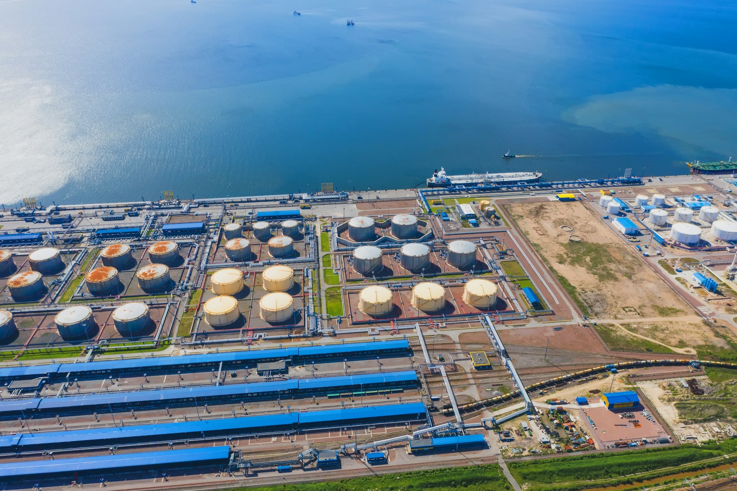 Aerial view of an oil port with tankers, storage tanks and rail yard